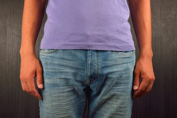 Young man wearing purple blank t-shirt, standing in a studio on — ストック写真