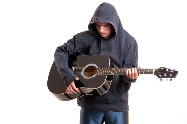 Tonåring pojke spelar en akustisk gitarr med mycket känsla — Stockfoto