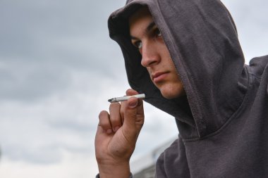 dalgın ve endişeli genç siyah hoodie ile yasaktır çiğ çocuktur
