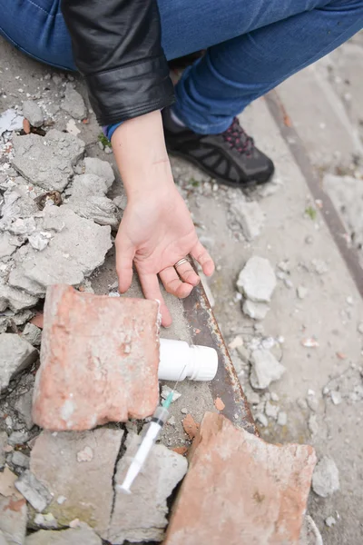 Mano de un adicto a las drogas llegando a una jeringa y pastillas. Simular la — Foto de Stock