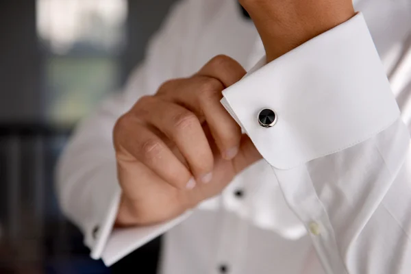 Close-up van een hand man hoe draagt shirt en cufflink witte — Stockfoto