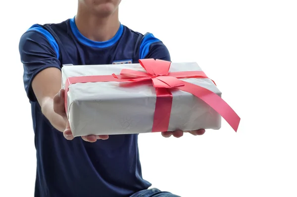 Jovem oferecendo um presente branco com fita vermelha para você. Isolados — Fotografia de Stock