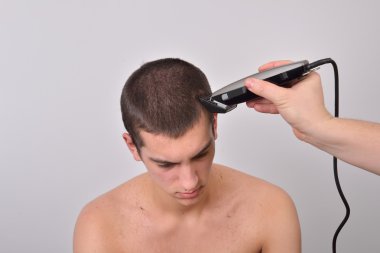 Genç adam bir saç kesimi saç kesme makineleri ile gelecek