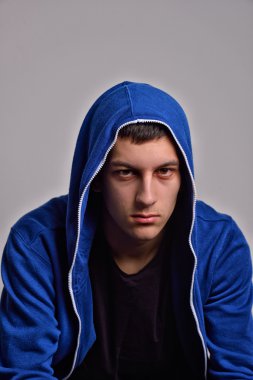 Mavi kapüşonlu sweatshirt giyen genç kendinden emin bir adam portresi