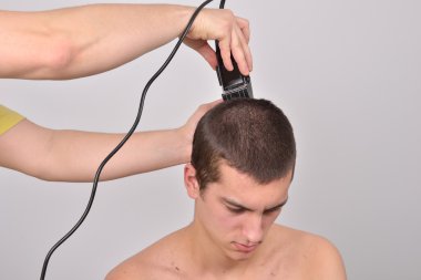 Genç adam bir saç kesimi saç kesme makineleri ile gelecek