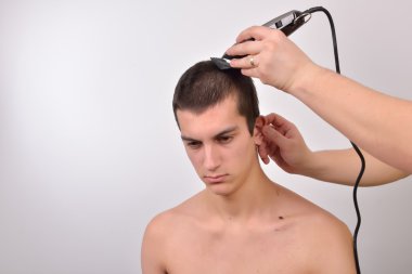 Genç adam bir saç kesimi saç kesme makineleri ile gelecek