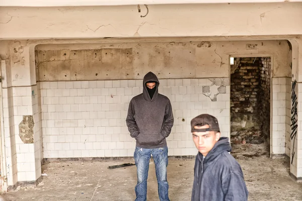 Two street hooligans or rappers standing in a old abandoned buil — Stock Photo, Image