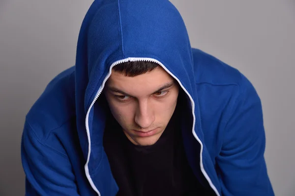 Portrait of a confident young man wearing blue hooded sweatshirt — Stock Photo, Image
