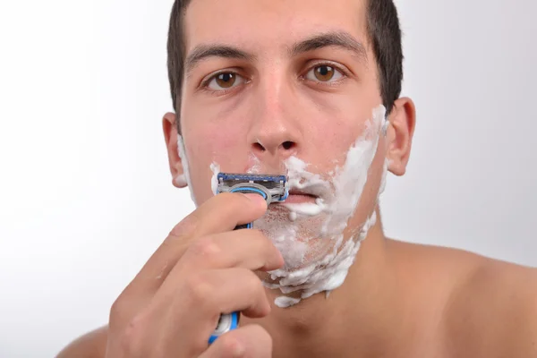 Bonito jovem com lotes de creme de barbear em seu rosto prepar — Fotografia de Stock