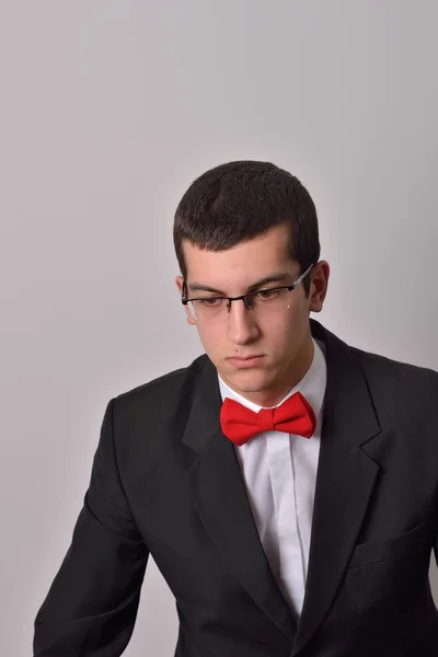 Retrato de um elegante jovem homem de moda de smoking preto posando — Fotografia de Stock