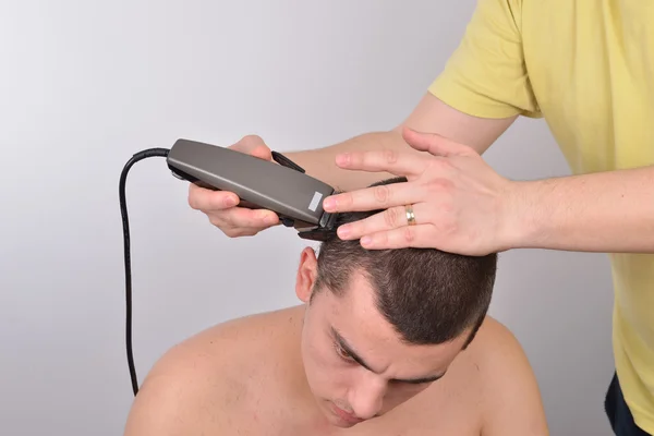 Primer plano de un estudiante masculino que tiene un corte de pelo con cortadores de pelo —  Fotos de Stock