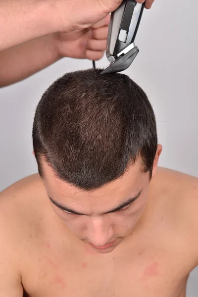 Close up retrato de jovem bonito homem cortando seu cabelo — Fotografia de Stock