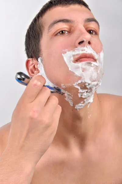 Hombre joven guapo con un montón de crema de afeitar en la cara es sha —  Fotos de Stock