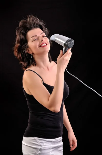 Woman with long hair holding blow dryer — Stock Photo, Image