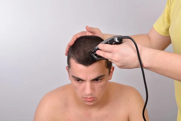 Primer plano de un estudiante masculino que tiene un corte de pelo con cortadores de pelo —  Fotos de Stock