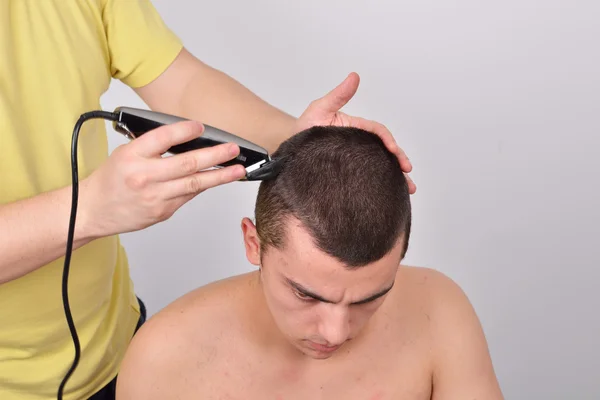 Primer plano de un estudiante masculino que tiene un corte de pelo con cortadores de pelo —  Fotos de Stock