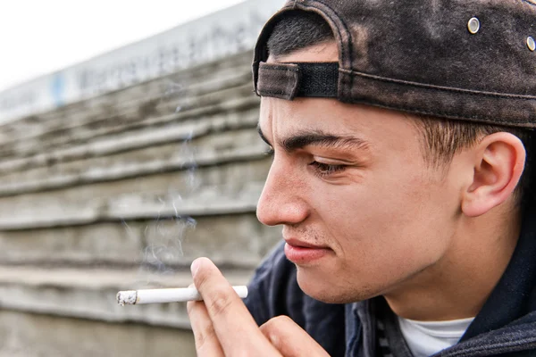 Imagen sobre fumar. joven se ríe y fuma un cigarro — Foto de Stock