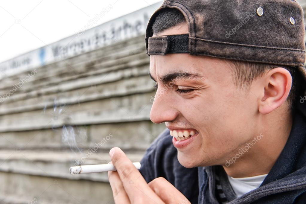 Picture about smoking. young man is laughing and smoking a cigar