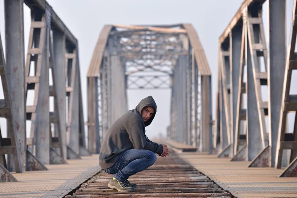 Pensador triste adolescente em depressão sentado agachado na ponte — Fotografia de Stock