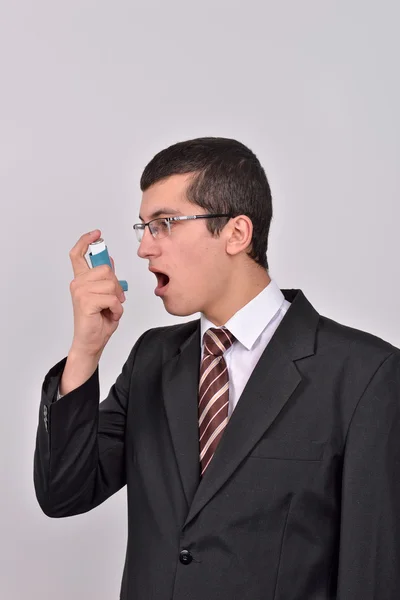 Hombre joven caucásico en traje de usar un inhalador de asma para pr —  Fotos de Stock