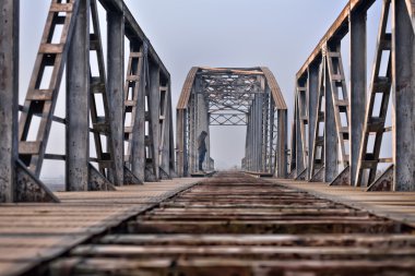 Depresyon köprüde günbatımında oturan üzgün genç. 