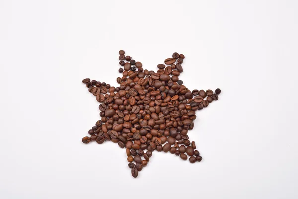 Símbolo de estrela feito de grãos de café no fundo branco — Fotografia de Stock