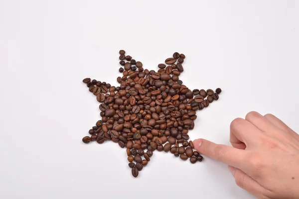 Mano de una mujer haciendo un símbolo de la estrella hecha de granos de café en w —  Fotos de Stock