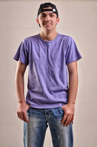 Handsome young man with backwards cap on his head posing in stud — Stock Photo, Image