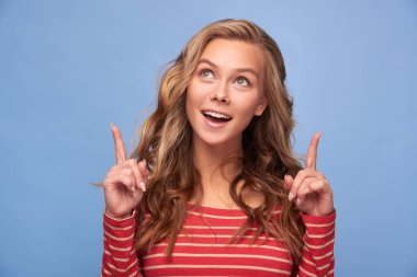 Çekici, heyecanlı, düz parmakları boş bir kızın yakın çekimde çekilmiş fotoğrafı mavi arka planda sarı çizgili, kırmızı elbiseli yeni bir afiş gösteriyor.