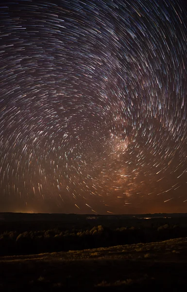 Night sky, spiral star trails and the forest — Stock Photo, Image