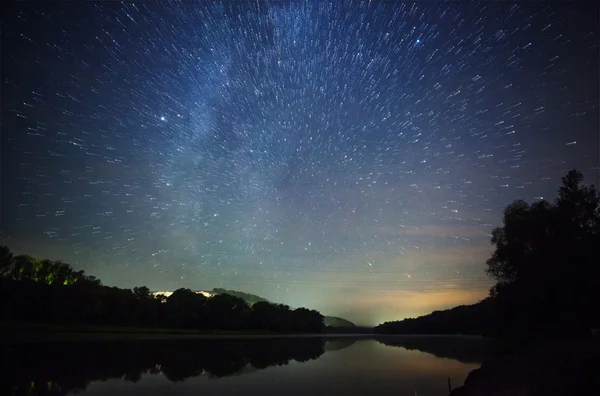 Un hermoso cielo nocturno, la Vía Láctea, senderos estelares y los árboles — Foto de Stock