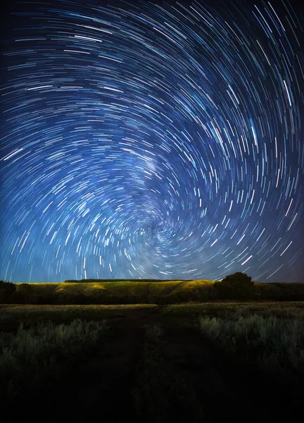 Belo céu noturno, trilhas de estrelas em espiral e a floresta — Fotografia de Stock