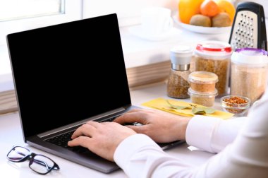 Yemek kursları. Masada bir dizüstü bilgisayar ve ders için bir sürü ürün var. Çevrim içi öğrenim.