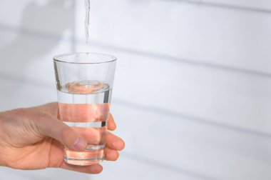 Karlı zeminde bir bardak temiz mavi su. Temiz, sağlıklı su kavramı. Dünya Su Günü.