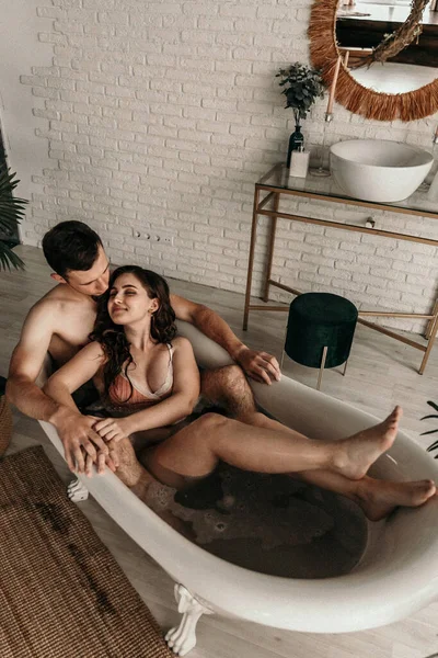 Aşıkken banyo yapan gençlerin fotoğrafı. Zihinsel dinlenme. Cinsel içgüdü. Cinsel tutku. Yakışıklı adam güzel kız arkadaşına karşı bir şeyler hissediyor. Aşıklar tuvalette neşe. Gürültü, taneli etki