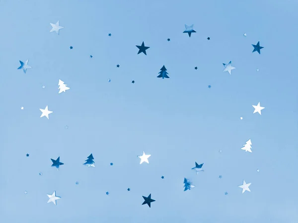 Confetti estrelas e árvores cintilantes sobre fundo azul. — Fotografia de Stock