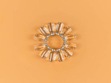 Sarı zemin üzerinde sıvı ilaç bulunan bir sürü şişe..