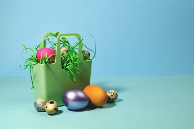 Mavi arka planda silikon bir sepette paskalya yumurtaları.