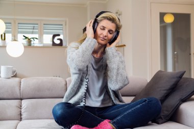 kulaklıklar ile kanepede oturan kadın