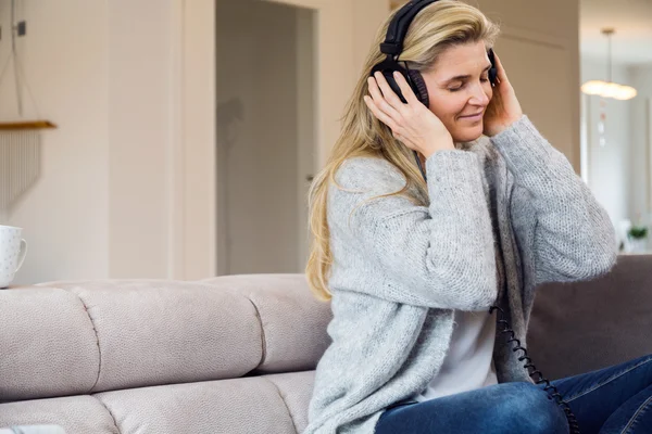Evde müzik dinleyen bir kadın — Stok fotoğraf
