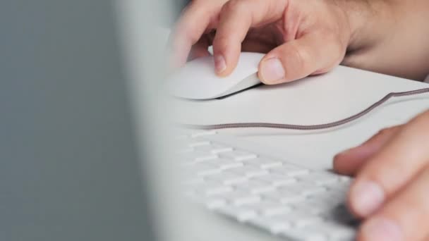 Человек, работающий с компьютерной мышью и клавиатурой — стоковое видео