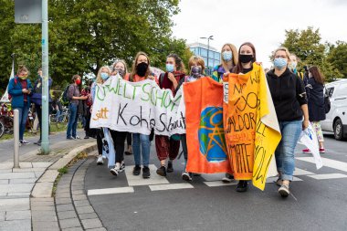 Gottingen, Almanya. 2020 sonbaharında. Gelecek için cuma günleri. Elinde bayrak tutan bir grup genç kadın iklim değişikliğine karşı yürüyor. 