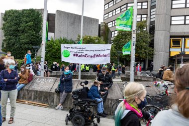 Gottingen, Almanya. 2020 sonbaharında. Gelecek için cuma günleri. İklim değişikliğini protesto etmek için pankartın yanında oturan insanlar. Düşük ihtimal. 