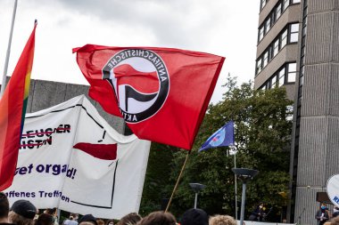 Gottingen, Almanya. 2020 sonbaharında. Protesto sırasında dışarıda kırmızı faşizm bayrağı sallanıyor.. 