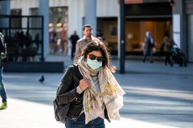 2020 baharında. Frankfurt, Almanya. Şehirde yüz maskesi takan bir kadın. Orta boy.. 