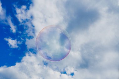 Resimli gökyüzü arkaplanında yüzen şeffaf baloncuk. 