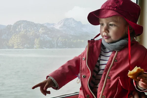 托德勒穿着外套 戴着帽子 一边选择一边看一边看 湖泊和山水景观背景 — 图库照片