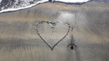 Islak kumsal, kalp şeklinde iz bırakmış.. 
