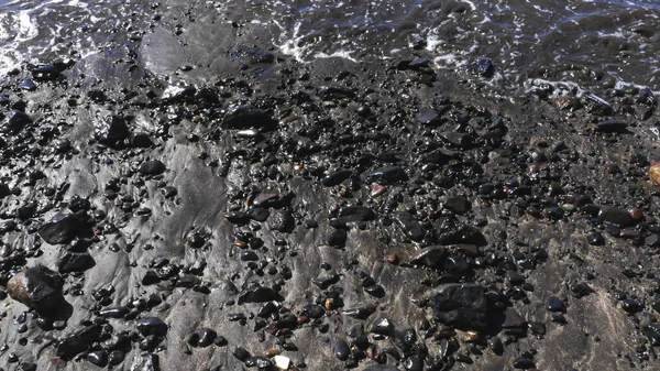 Bagnato Sabbia Nera Spiaggia Con Rocce Direttamente Sopra — Foto Stock