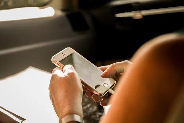 Woman using smartphone in car — Stock Photo, Image